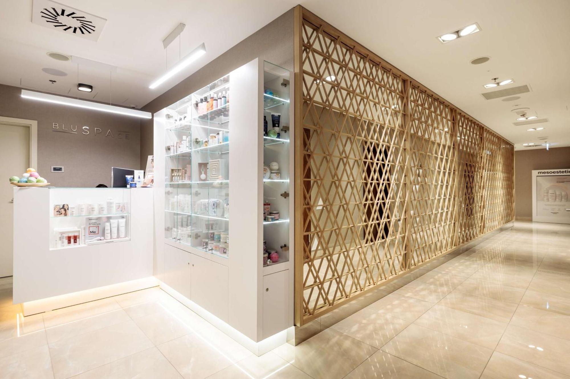 Radisson Blu Resort Swinoujscie Luaran gambar The photo shows a modern interior, likely from a spa or skincare clinic. On the left, there is a reception area with a sleek white counter and an illuminated display showcasing various skincare products. The wall behind the reception features a glass