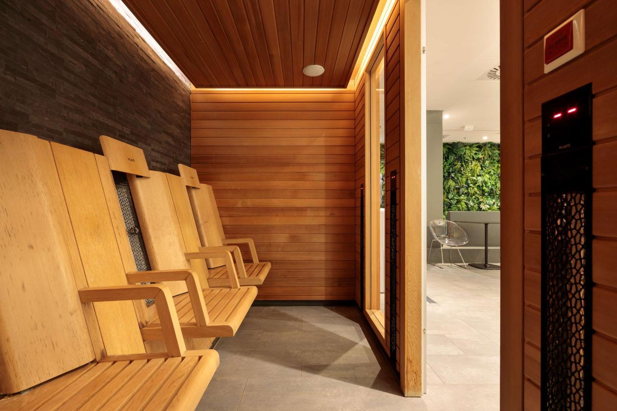 Radisson Blu Resort Swinoujscie Luaran gambar The photo shows a sauna area featuring wooden benches arranged along the walls. The interior is designed with natural wood paneling and has a warm, inviting ambiance. There is a glass door visible, which likely leads to another space, and some greene